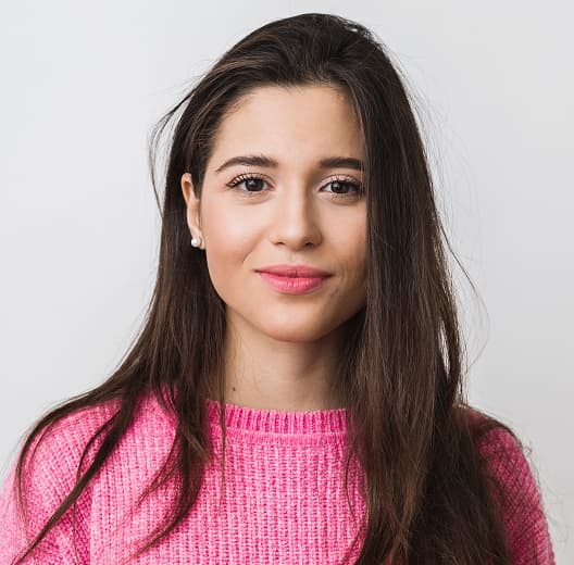 Smiling woman in a pink sweater, long hair, brunette