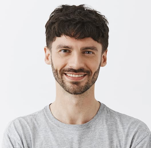Smiling man in a gray T-shirt, short haircut, brunette with a beard